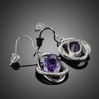Close up of KHAISTA purple halo crystal drop earrings