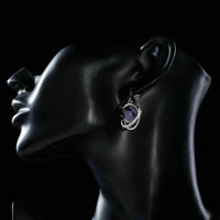 Side angle view of KHAISTA purple halo crystal drop earrings