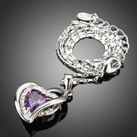Side angle view of KHAISTA purple crystal heart pendant necklace