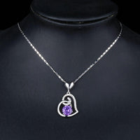Side angle view of KHAISTA purple heart pendant chain necklace