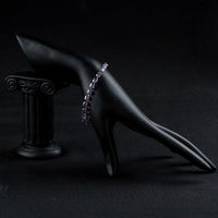 Side angle view of KHAISTA purple CZ link chain bracelet