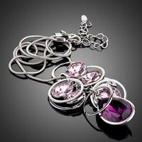 Side angle view of KHAISTA purple Stellux Austrian crystal pendant necklace