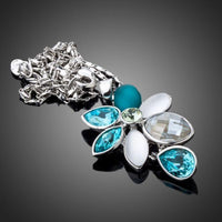 Side angle view of KHAISTA raindrop daisy crystal pendant necklace