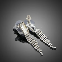 Close up of KHAISTA rectangle dangle drop earrings