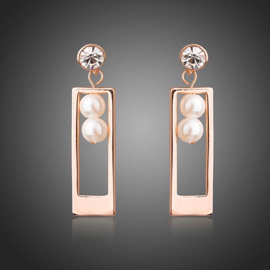 KHAISTA rose gold rectangle pearl drop earrings on white background