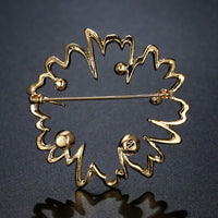 Side angle view of Khaista red rhinestone flower brooch