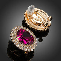 Side angle view of KHAISTA red CZ diamante oval stud earrings