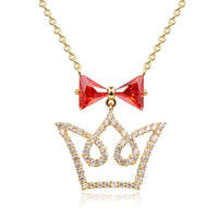 Side angle view of KHAISTA red CZ bow knot crown pendant necklace