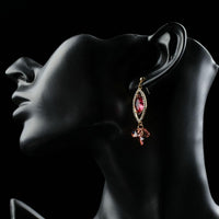 Close up of KHAISTA red CZ dangle earrings