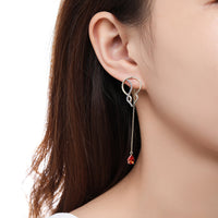 Side angle view of KHAISTA red CZ long drop earrings