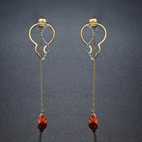 Close up of KHAISTA red CZ long drop earrings
