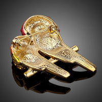 Close-up of red crystals on Khaista lovebirds brooch