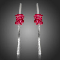 Side angle view of KHAISTA red rose tassel crystal drop earrings
