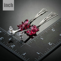 Close up of KHAISTA red rose tassel crystal drop earrings