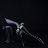 Side angle view of KHAISTA rhodium plated black artistic cuff bangle