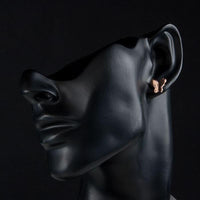 Close up of KHAISTA rose gold butterfly earrings