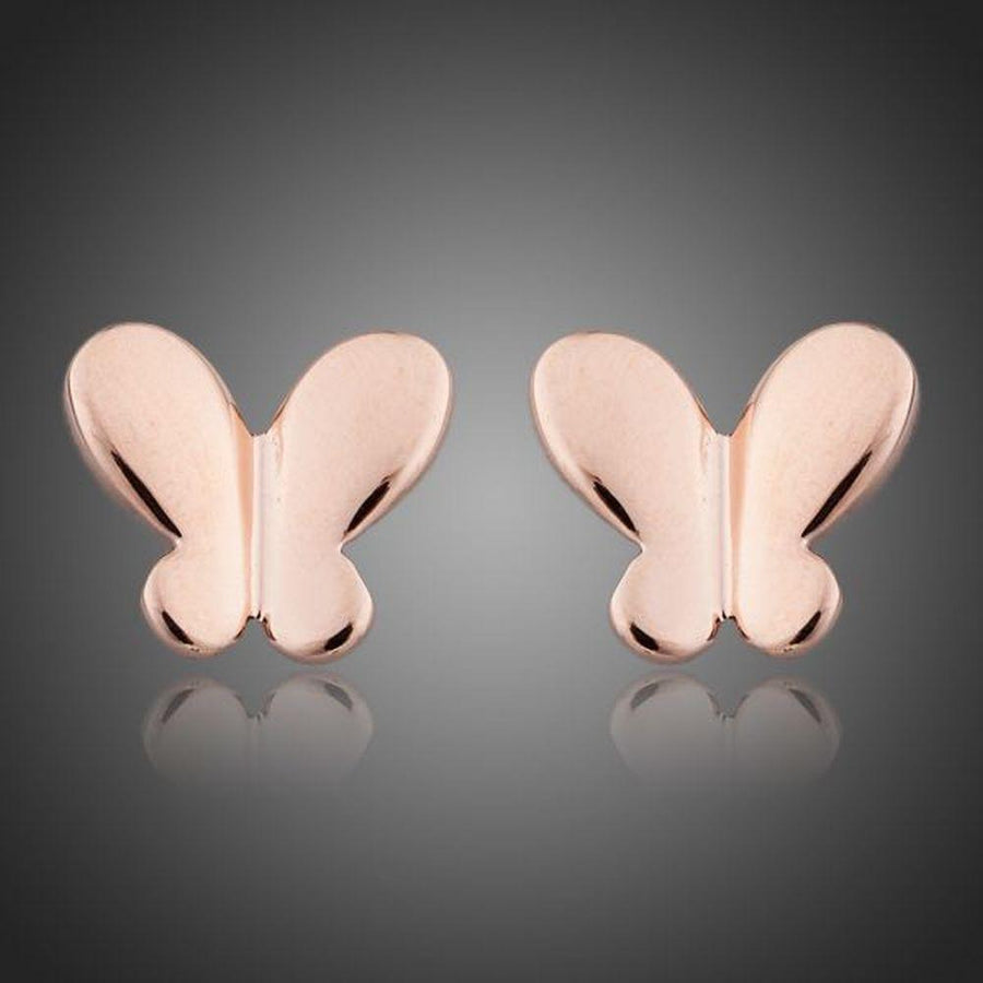 KHAISTA rose gold butterfly earrings on white background