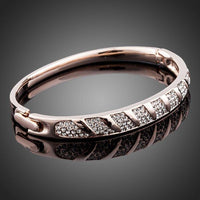 Side angle view of KHAISTA rose gold classic bangle