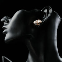 Close up of KHAISTA rose gold crystal clip earrings