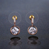 Close up of KHAISTA rose gold crystal drop earrings