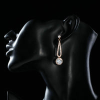 Close up of KHAISTA rose gold CZ drop earrings