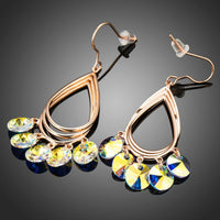 Side angle view of KHAISTA rose gold crystal dangle earrings