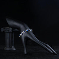Side angle view of KHAISTA round blue CZ bracelet