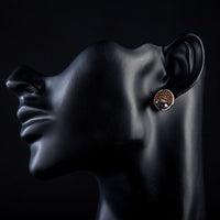 Side angle view of KHAISTA round chocolate crystal stud earrings