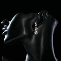Side angle view of KHAISTA round crystal chain drop earrings