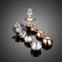 Close up of KHAISTA round crystal chain drop earrings