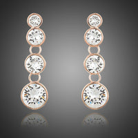 KHAISTA round crystal chain drop earrings on white background