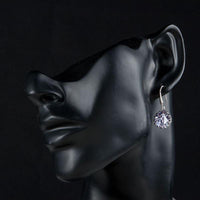 Side angle view of KHAISTA round CZ drop earrings