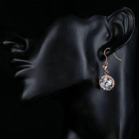 Side angle view of KHAISTA round CZ fashion drop earrings