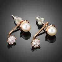 Side angle view of KHAISTA round CZ pearl stud earrings