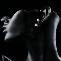 Close up of KHAISTA round CZ pearl stud earrings