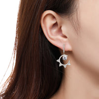 Side angle view of KHAISTA round crystal dangle earrings