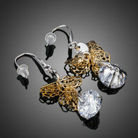 Close up of KHAISTA round dangling CZ drop earrings