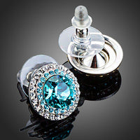 Close up of KHAISTA round deep sea crystal stud earrings