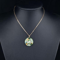 Side angle view of KHAISTA round ocean waves crystal pendant necklace