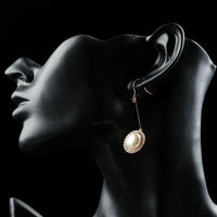 Close up of KHAISTA round pearl earrings