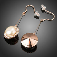 Side angle view of KHAISTA round pearl earrings