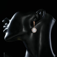 Side angle view of KHAISTA round CZ drop earrings