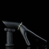 Side angle view of KHAISTA royal green pear cut crystal bracelet