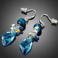 Close up of KHAISTA sea blue crystal drop earrings