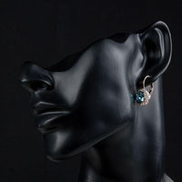 Side angle view of KHAISTA sea blue round crystal earrings