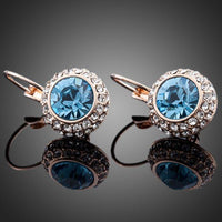 Close up of KHAISTA sea blue round crystal earrings