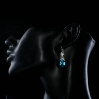 Side angle view of KHAISTA sea blue rhinestone crystal drop earrings