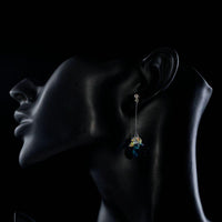 Side angle view of KHAISTA sea blue rhinestone heart drop earrings