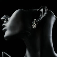 Close up of KHAISTA crystal sheep design dangle earrings