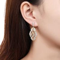 Side angle view of KHAISTA Austrian crystal shield dangle earrings